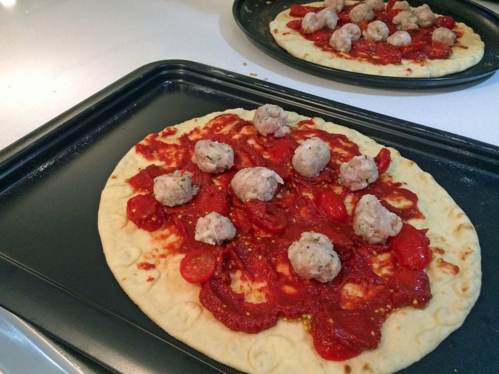 sausage and tomato pizzas